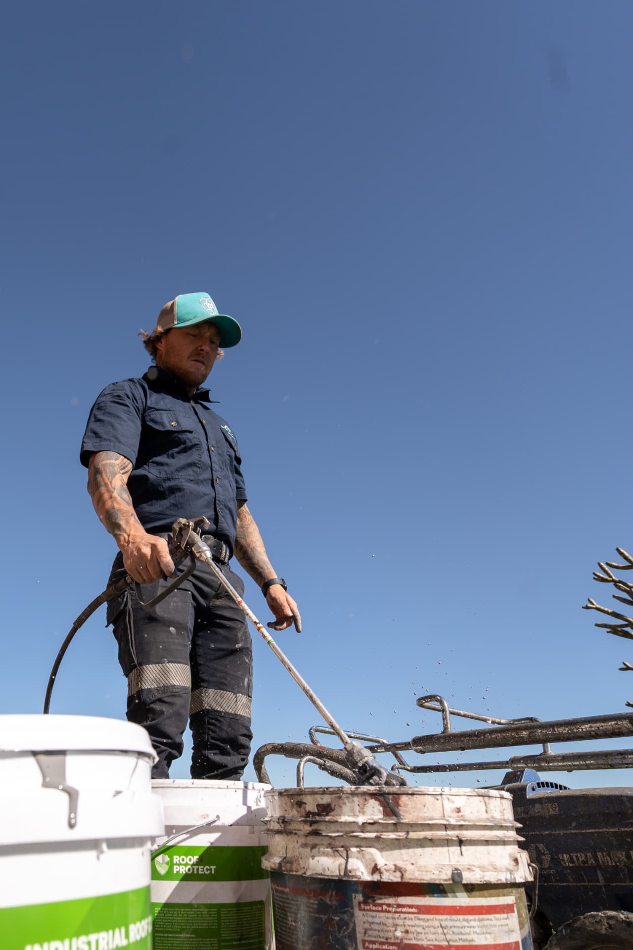 Roof coating being mixed on site before spraying